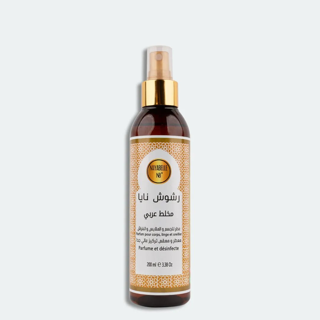 Flacon spray de parfum "Rchouch Mokhalat" signé Nayabelle, au design épuré avec un motif doré élégant sur l'étiquette. Ce parfum polyvalent Oud est destiné au corps, au linge et aux oreillers, offrant une fragrance orientale intense tout en désinfectant. Contenance de 200 ml.
