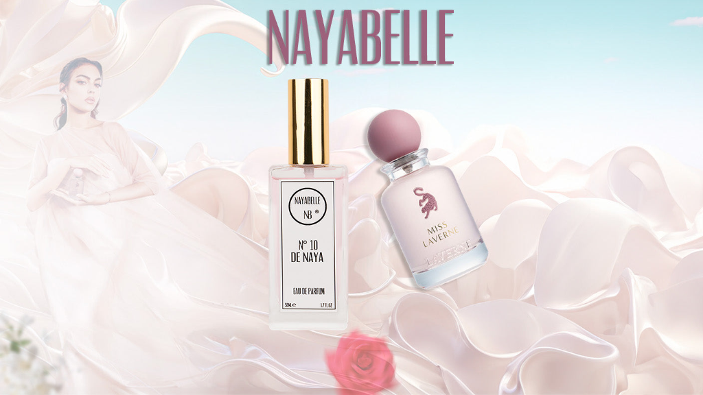 Parfum N°10 de Naya de Nayabelle et flacon Miss Laverne, posés sur un fond satiné rose clair. Une élégante femme en robe fluide crème ajoute une touche de grâce et de raffinement à la scène, accompagnée d’une rose rouge symbolisant la féminité et la délicatesse.