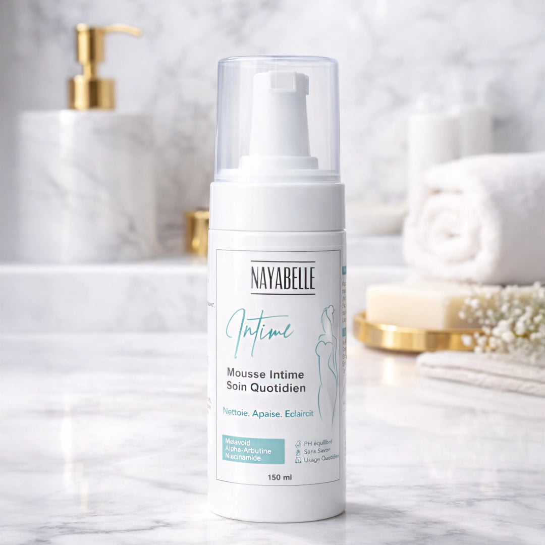 Mousse intime Nayabelle Soin Quotidien posée sur un plan de travail en marbre, formulée avec du Melavoid et de l'Alpha-Arbutine pour nettoyer, apaiser et éclaircir en douceur.