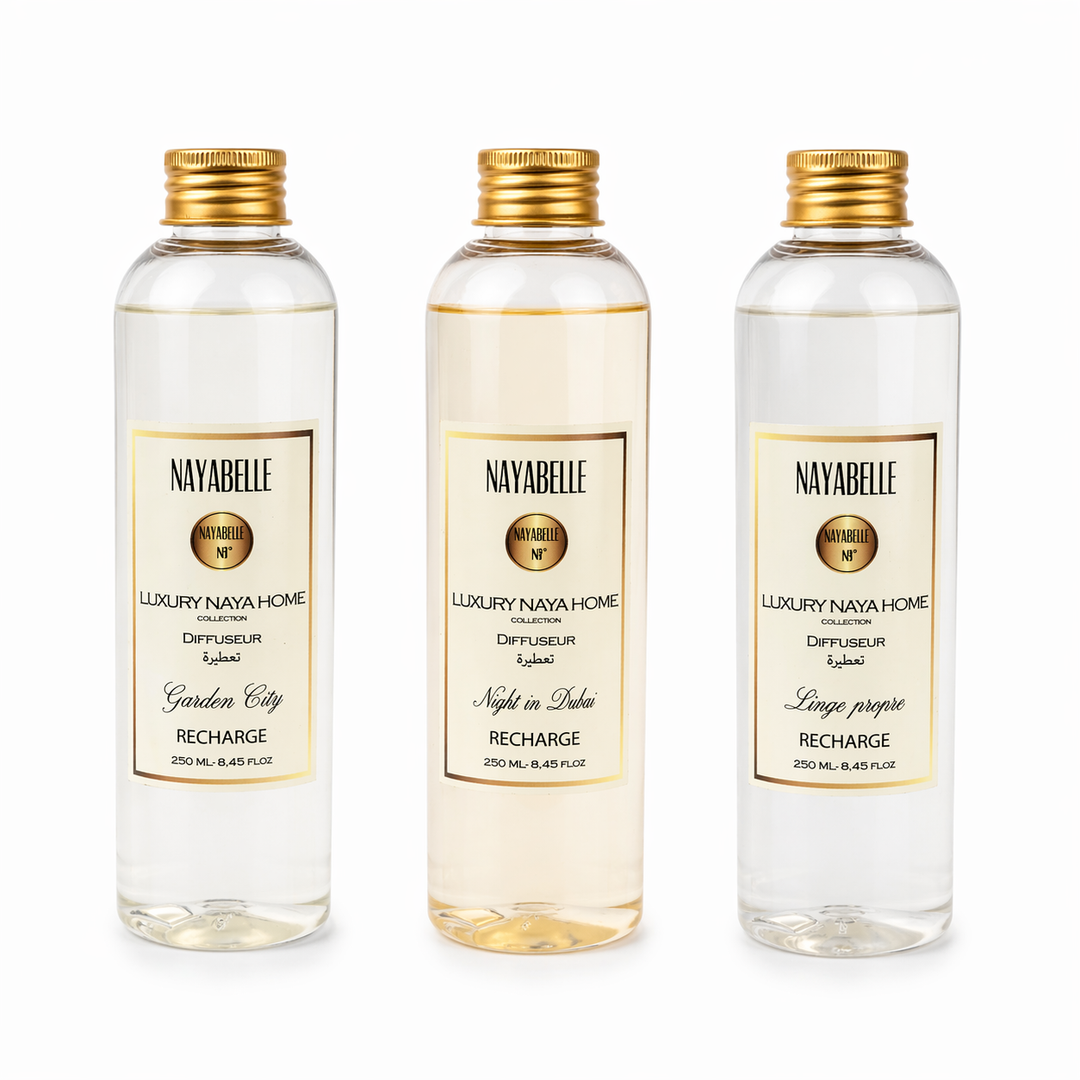 Trois flacons de recharge pour diffuseurs d’intérieur de la collection Luxury Naya Home par Nayabelle. Chaque flacon de 250 ml présente un design élégant avec bouchon doré et étiquette raffinée. Parfums disponibles : Garden City, Night in Dubai et Linge propre.